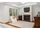 Cozy living room featuring a fireplace and a large window providing natural light at 1319 Glen Cedars Dr, Smyrna, GA 30126