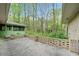 Backyard patio featuring a decorative brick wall, green exterior and a wooded background creating a private and peaceful atmosphere at 1478 Biltmore Ne Dr, Atlanta, GA 30329