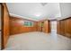 Spacious basement featuring paneled walls, tiled flooring, closet, and natural light from a window at 1478 Biltmore Ne Dr, Atlanta, GA 30329