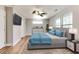 Bright bedroom with light wood floors, ceiling fan, dresser and a comfortable bed dressed in blue bedding at 870 Gaston Sw St, Atlanta, GA 30310