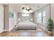 Bright bedroom with light wood floors, ceiling fan, rug and a comfortable bed dressed in white bedding at 870 Gaston Sw St, Atlanta, GA 30310