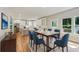 Bright dining area with blue upholstered chairs adjacent to a white kitchen and large windows at 870 Gaston Sw St, Atlanta, GA 30310