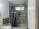Bathroom with gray tile, a window, and shower with gray curtain and a recessed soap/shampoo holder at 1841 Bayberry Sw Dr, Atlanta, GA 30311