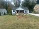 Charming craftsman home features a covered porch with a manicured lawn and mature trees at 1841 Bayberry Sw Dr, Atlanta, GA 30311