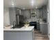 A modern kitchen with grey cabinets, quartz countertops, stainless steel appliances, and wood flooring at 1841 Bayberry Sw Dr, Atlanta, GA 30311
