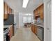 Galley kitchen features wood cabinets, stainless appliances, tiled backsplash, and eat-in dining area at 2793 Saddle Horn, Snellville, GA 30039
