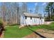 Rear exterior of home showing walkout basement access, grassy area, and wooded backdrop at 3143 Lee Cir, Buford, GA 30518