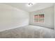 Spacious bedroom features gray carpet, a window, and ample wall space at 4419 Bellwood Cir, Atlanta, GA 30349
