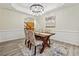 Inviting dining room features wainscoting, modern chandelier, and wood table with seating for four at 4419 Bellwood Cir, Atlanta, GA 30349