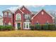 A stunning red brick two-story home with bay windows, shutters, and manicured landscaping at 4419 Bellwood Cir, Atlanta, GA 30349