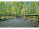 Back deck great for outdoor entertaining, surrounded by a lush green forest and natural light at 2100 Kings Valley Dr, Lawrenceville, GA 30043