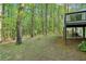 Wooded backyard featuring mature trees, a classic wooden fence, and an outdoor deck for relaxation at 2100 Kings Valley Dr, Lawrenceville, GA 30043