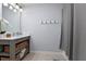 Bathroom featuring a marble countertop, white sink, grey cabinets, and modern shelving unit at 2100 Kings Valley Dr, Lawrenceville, GA 30043