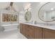 Luxurious bathroom with double vanity, soaking tub, chandelier, and large window, creating a spa-like experience at 2100 Kings Valley Dr, Lawrenceville, GA 30043