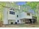 An exterior shot highlights the deck, trees, and multi-level construction of this spacious property at 2100 Kings Valley Dr, Lawrenceville, GA 30043