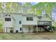 Exterior shot shows a multi-level home with a cozy deck and lush greenery surrounding the property at 2100 Kings Valley Dr, Lawrenceville, GA 30043