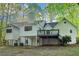 This home boasts a spacious, multi-level back exterior with a deck overlooking a partially wooded lot at 2100 Kings Valley Dr, Lawrenceville, GA 30043