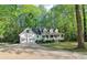 Beautiful home exterior with a driveway, a big front lawn, mature trees, and a front porch at 2100 Kings Valley Dr, Lawrenceville, GA 30043