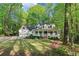 Beautiful home exterior with large front lawn, lush mature trees, and a charming front porch at 2100 Kings Valley Dr, Lawrenceville, GA 30043