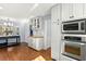 Modern kitchen features white cabinets, stainless steel appliances, and hardwood floors, offering style and functionality at 2100 Kings Valley Dr, Lawrenceville, GA 30043