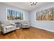 Sun-filled sitting room boasts large windows, hardwood flooring, and comfortable accent chairs at 2100 Kings Valley Dr, Lawrenceville, GA 30043