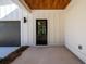 Covered front entrance featuring wood ceiling and a sleek black front door and gray garage door at 2526 Abner Nw Pl, Atlanta, GA 30318