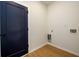 Laundry room with durable laminate flooring and modern navy door at 2526 Abner Nw Pl, Atlanta, GA 30318