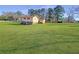 Home exterior with lush green lawn and storage building on a sunny day at 3415 Spot Rd, Cumming, GA 30040