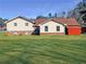 The home's rear exterior with a green lawn and a small storage building at 3415 Spot Rd, Cumming, GA 30040