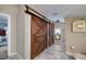 Bathroom with wood sliding barn doors, modern vanity, and walk-in shower at 590 Yancey Cir, Covington, GA 30014