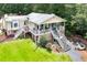 Two-story lakehouse with multiple decks, stone accents, and a fire pit area for outdoor enjoyment at 590 Yancey Cir, Covington, GA 30014