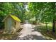 Storage shed with a moss-covered roof along a paved driveway at 590 Yancey Cir, Covington, GA 30014