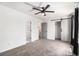 Spacious bedroom with a ceiling fan, gray walls, closet with sliding barn door, and neutral carpet at 732 Jamestown Xing, Jonesboro, GA 30238