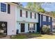 Inviting townhome with light blue facade, showcasing a well-maintained lawn and brick pathway to the front door at 732 Jamestown Xing, Jonesboro, GA 30238