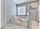 Bathroom area featuring soaking tub with tile flooring and bright window at 841 Butterworth Rd, Canton, GA 30114