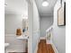 Well-lit bathroom with pedestal sink and framed mirror; note the stairs leading to the next level at 2610 Ginger Dr, Buford, GA 30519