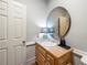 This half bathroom has a wood vanity, unique round mirror, and wainscoting at 2610 Ginger Dr, Buford, GA 30519
