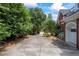 Long driveway leading to an attached garage surrounded by mature trees and lush landscaping at 2610 Ginger Dr, Buford, GA 30519