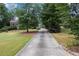 Expansive driveway leading to a beautiful home, surrounded by a well-manicured lawn and mature trees at 2610 Ginger Dr, Buford, GA 30519