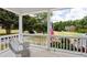 Relaxing porch view with a wicker chair and a scenic landscape featuring a manicured lawn and mature trees at 2610 Ginger Dr, Buford, GA 30519