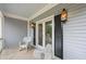 Cozy front porch featuring wicker chairs, a vintage rug, and stylish wall-mounted lanterns at 2610 Ginger Dr, Buford, GA 30519