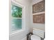 Neutral toned powder room featuring decorative wall decor, window, and toilet at 2610 Ginger Dr, Buford, GA 30519