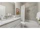 Bathroom featuring granite countertop, white cabinets, and tiled shower and tub at 2811 Shady Valley Ne Dr, Brookhaven, GA 30324