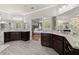Bright bathroom featuring double vanities with granite counters and dark wood cabinets and an open doorway to the bedroom at 2811 Shady Valley Ne Dr, Brookhaven, GA 30324