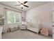 Bedroom with crib, white walls with tasteful floral print, chair, and window with natural light at 2811 Shady Valley Ne Dr, Brookhaven, GA 30324
