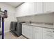 Laundry room with white cabinets, gray countertops, and front load washer and dryer at 2811 Shady Valley Ne Dr, Brookhaven, GA 30324