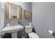 Stylish powder room with pedestal sink, decorative mirror, and grey walls at 2811 Shady Valley Ne Dr, Brookhaven, GA 30324