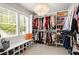 Spacious walk-in closet with custom shelving, hanging racks, shoe storage, and a chandelier at 2811 Shady Valley Ne Dr, Brookhaven, GA 30324