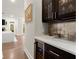 Elegant wet bar with dark cabinetry, wine fridge, and marble countertops at 2811 Shady Valley Ne Dr, Brookhaven, GA 30324