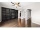 Spacious bedroom with a ceiling fan, hardwood floors, and custom built-in shelving at 3435 Kingsboro Ne Rd # 603, Atlanta, GA 30326